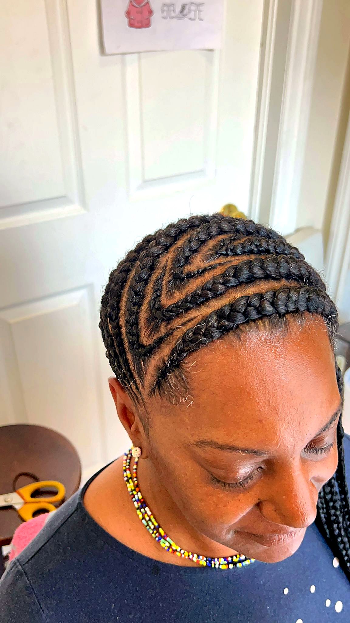 Geometric cornrow braiding on Afro-American client